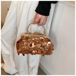 Detail of gold sequin evening bag featuring bead handle and metal clasp closure