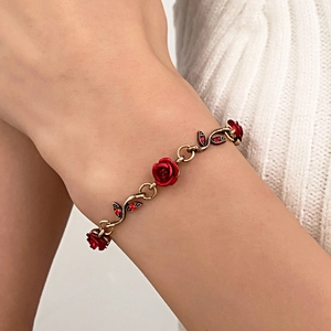 Bracelet doré vintage avec roses rouges et petits gemmes rouges sur le poignet