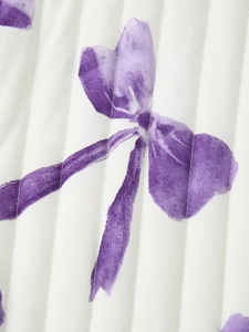 Detailed macro view of purple floral print on quilted white fabric with vertical stitching