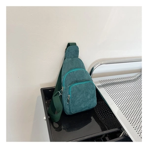 Detailansicht der dunkelgrünen Cord-Brusttasche mit drei Lagen Reißverschlusstaschen
