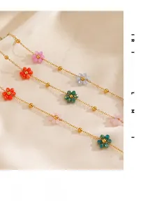 Detail showing 18K gold plated chains with multi-colored crystal flowers on champagne silk