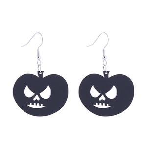 Detailed close-up of Halloween earrings featuring black acrylic carved pumpkin faces
