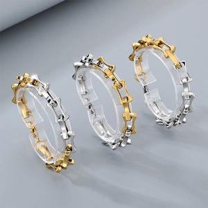 Three-piece set of gold and silver curved stainless steel bracelets on acrylic display