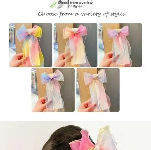 Close-up of rainbow organza bow hairpins with faux pearl chain trim for girls
