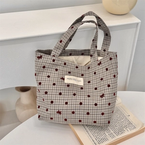 Détail du sac bento en toile grise à pois rouges et étiquette tissée SUZAKKA