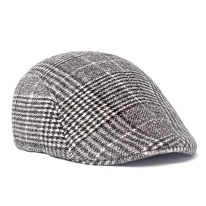 Close-up of classic wool blend newsboy cap showing detailed black and white plaid texture