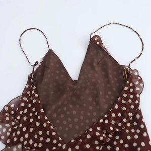 Detailed view of brown polka dot dress featuring mesh panel and delicate ruffle trim