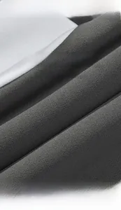 Detail van zachte antracietgrijze gebreide stoftextuur met drapering en hoogwaardig materiaal