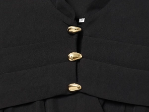 Close-up of black tailored blazer featuring three ornate gold buttons and size S tag