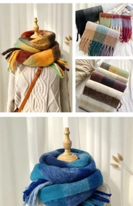 Close-up of soft knit rainbow plaid scarf with tassel details and plush texture