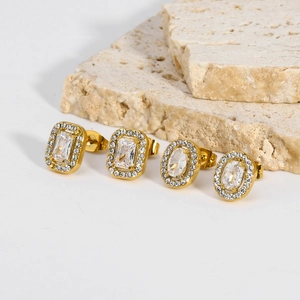 Macro view of gold-plated geometric stud earrings with rectangle and oval zircons on stones