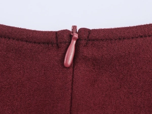 Détail de la fermeture éclair invisible sur la mini robe en tweed bordeaux chic