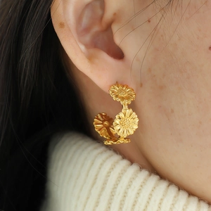 Retro 18k gold C-shaped daisy floral earrings on model for a minimalist style