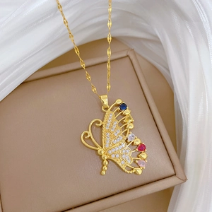 Close-up of golden butterfly pendant with sparkling colorful crystals on jewelry box