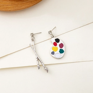 Artistic asymmetric earrings featuring a colorful paint palette and crossed brushes design
