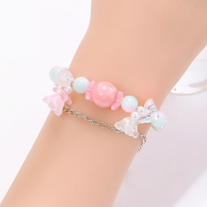 Primer plano de pulsera de doble capa con cuentas, flor de cristal rosa y mariposa