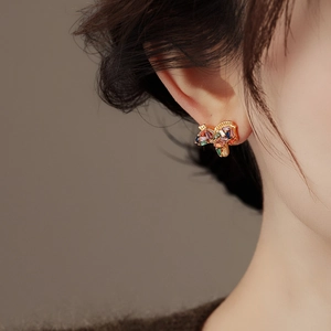 Elegant gold-plated stud earrings with colorful zircon crystals on a model