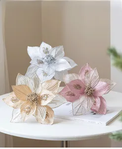 Three 25cm artificial Christmas flowers with glitter edges on a minimalist white table