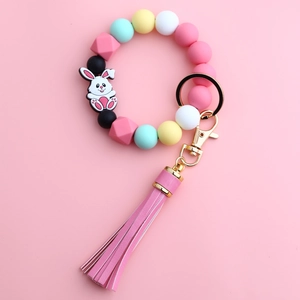 Macro shot of macaron silicone bead keychain bracelet with pink leather tassel and bunny charm