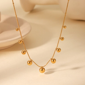 Close-up of golden stainless steel snake chain necklace with multiple polished beads