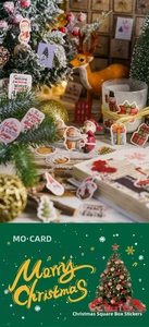 Detailed view of Christmas stickers on a notebook featuring Santa and reindeer designs