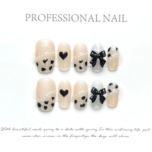 Detail of 10-piece handmade press-on nails with 3D bows, black hearts, and pearl chains