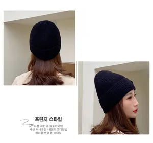 Detail showing the vertical knit texture and snug fit of the black wool beanie cap