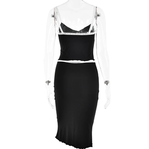 Detail of black two-piece set featuring white lace trim and scalloped hemline skirt