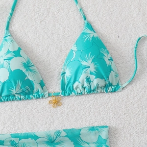 Detail of Tiffany blue bikini with white hibiscus floral print and gold metal flower pendant
