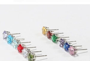 Macro shot of 12 multi-colored cubic zirconia stud earrings in stainless steel prong settings