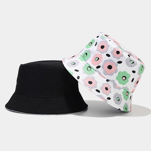 Detail of floral and black reversible bucket hats showing stitching and fabric texture