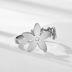 Polished silver floral stainless steel ring with hollow petal design on white background