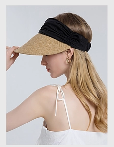 Detail of straw woven brim and black pleated headband on a summer open-top sun visor hat