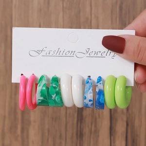 Close-up of 5 pairs of colorful C-shaped acrylic resin earrings on display card