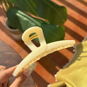 Detailed close-up of a 13.5cm cream resin butterfly hair claw clip with golden spring
