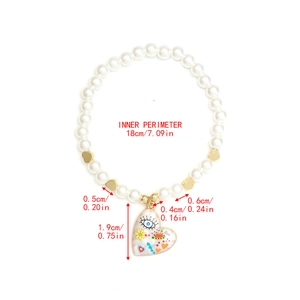 Detailed view of elastic pearl bracelet with evil eye heart pendant and dimensions