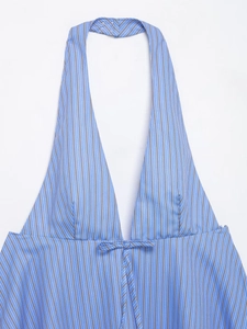 Detail of V-neck halter top featuring blue striped pattern and front bow-tie closure