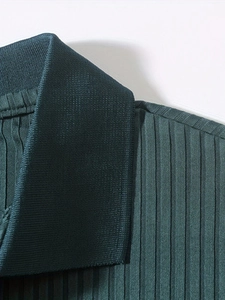 Close-up of deep green vertical ribbed texture and mandarin collar on men's polo shirt