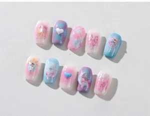 Detail of gradient press-on nails featuring 3D hearts, bows, and moon magic elements