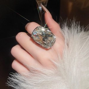 Detailed view of an oversized cushion-cut crystal ring with sparkling silver plating