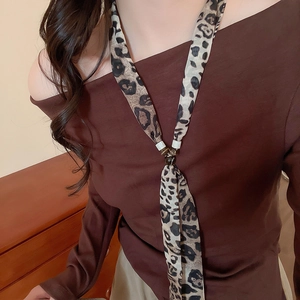 Detail of leopard print silk scarf necklace with resin beads on a model's neck
