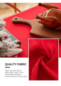 Close-up of red Christmas tablecloth featuring intricate snowflake jacquard texture and fabric detail