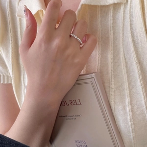 Close-up of minimalist 925 silver beaded ring on model holding a book in soft lighting