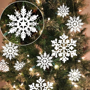 White snowflake hanging ornaments decorating a lit Christmas tree for party holiday decor