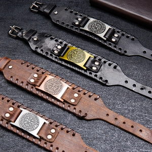 Macro view of wide leather bracelets with Nordic rune compass metal charms and buckles