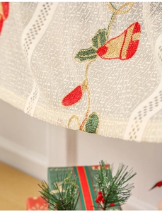 Close-up of Christmas bell embroidery on vintage lace cafe curtain with holiday decor
