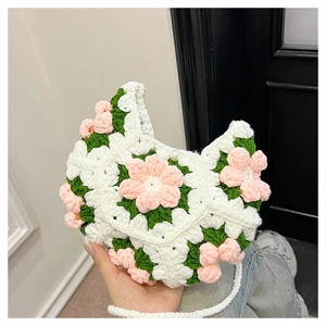 Close-up of handmade crochet puff flower bag with pink floral accents and pearl clasp