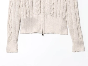 Detail of premium off-white cable knit texture and high-quality metal zipper on the cardigan
