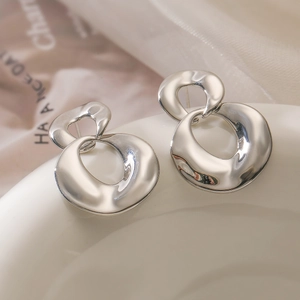 Modern polished silver geometric double hoop earrings on white ceramic for women