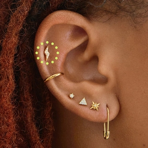 Detailed close-up of golden lightning, star, and triangle studs with paperclip earring set